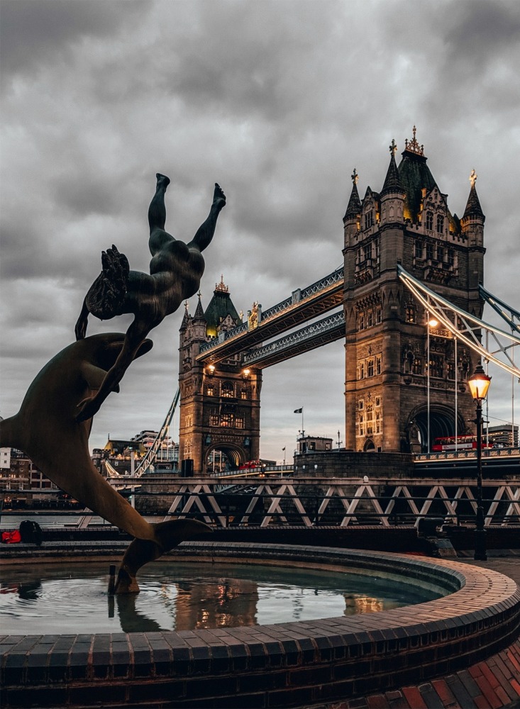 Girl with a Dolphin Fountain and Tower Bridge, London, England, UK.