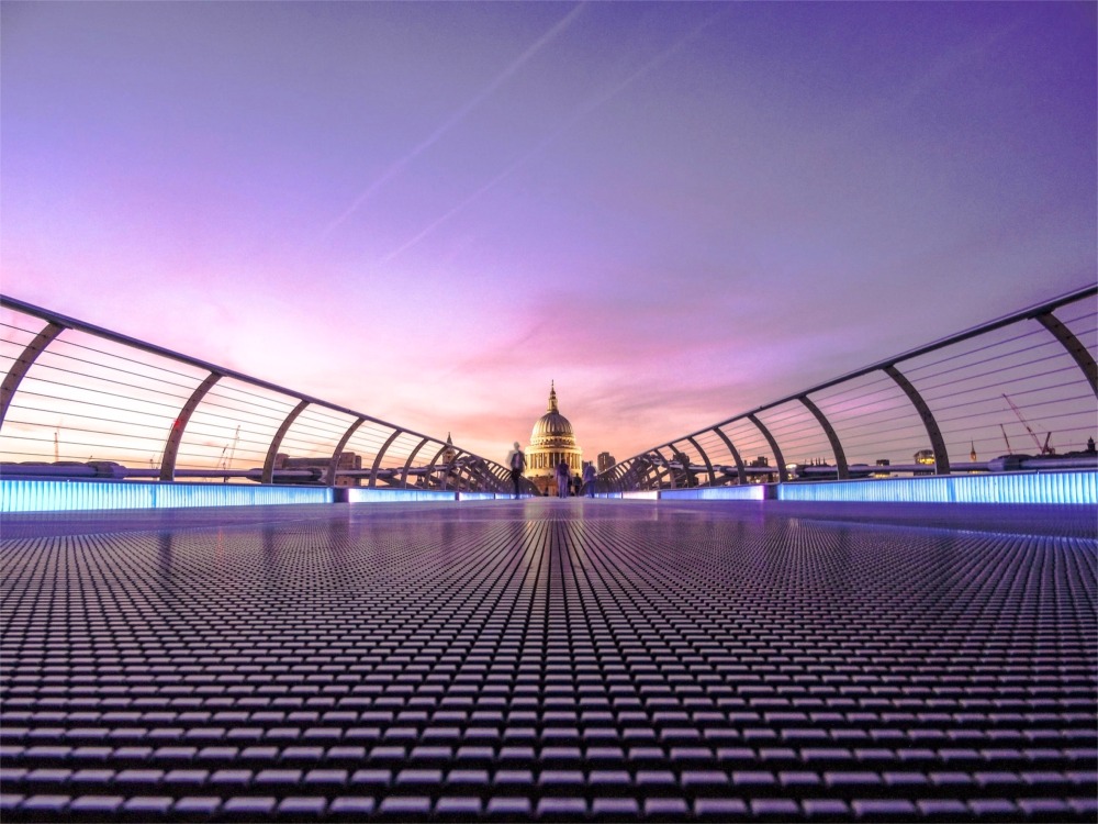 This is a modern artistic photograph looking north over the Millennium Bridge to the dome of St Paul's Cathedral in London, England.