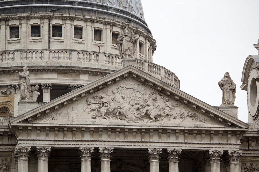 This photograph shows the exterior architectural and sculptural details of St Paul's Cathedral's western facade in London, England.